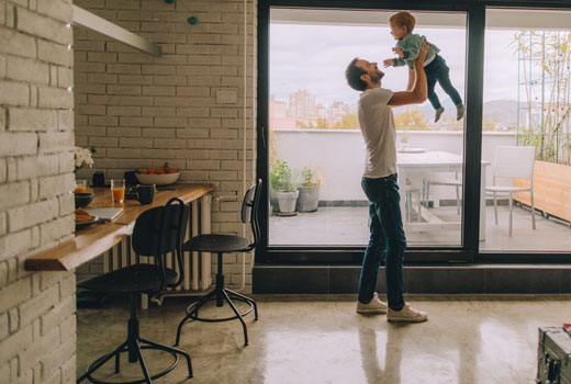 a man sitting with his daughter. He is reading a book