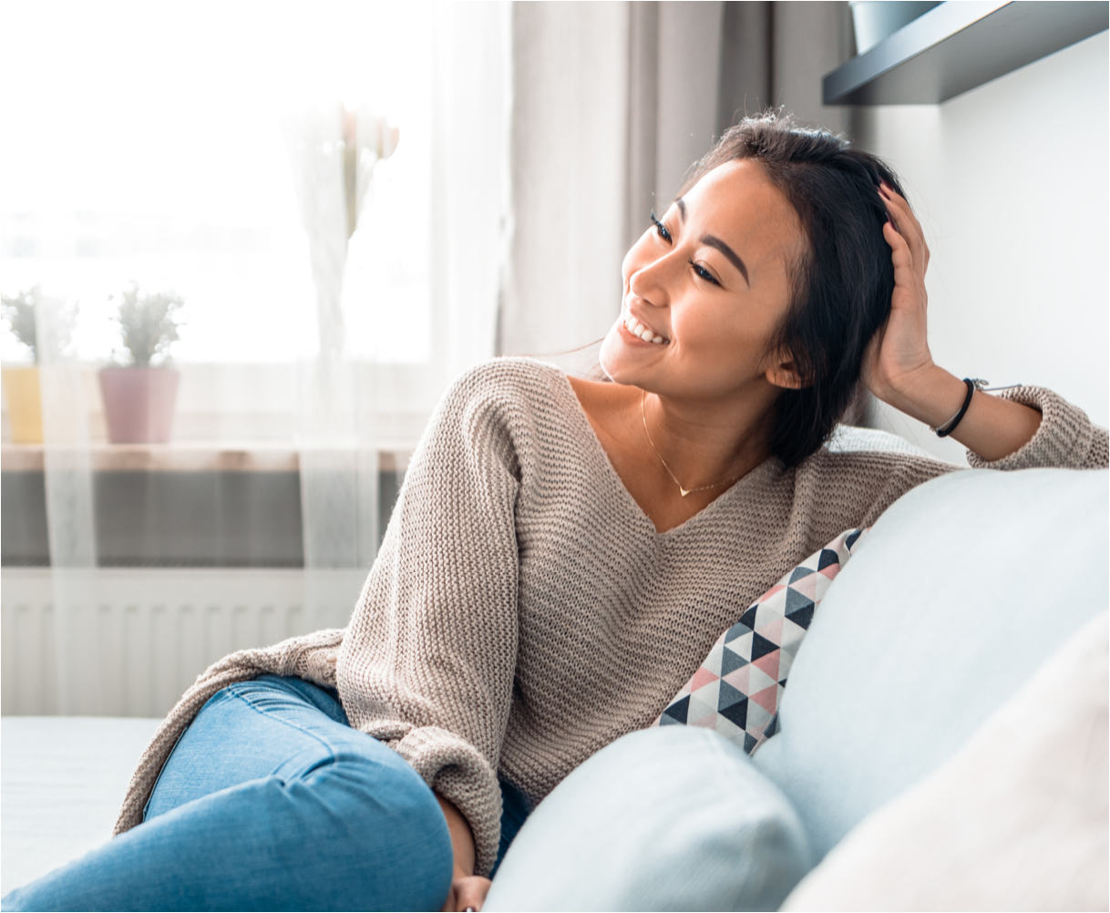 woman relaxing on a couch. She is smilling